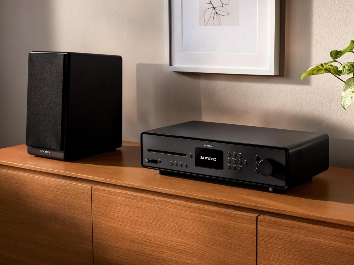 Schwarzer sonoro MAESTRO Quantum HiFi-Receiver mit Lautsprecher auf Holzsideboard im modernen Wohnzimmer