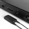 ESCAPE M1 AIR Modul auf einem HiFi-Verstärker – angeschlossen mit zwei Kabeln für Strom und Audioübertragung.