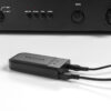 Detailansicht des ESCAPE M1 AIR Moduls auf einer dunklen Audioanlage – zeigt Anschlusskabel für einfache Integration.