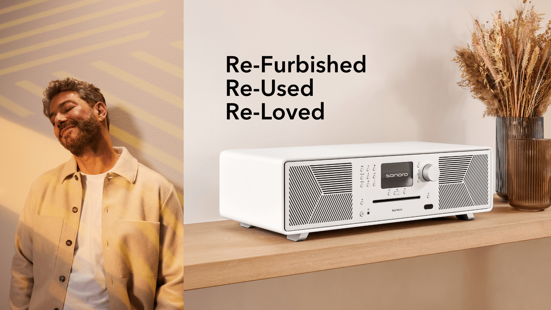 Refurbished sonoro Musiksystem in Weiß auf Holzregal, mit Trockenblumen – Kampagne für wiederaufbereitete Geräte.